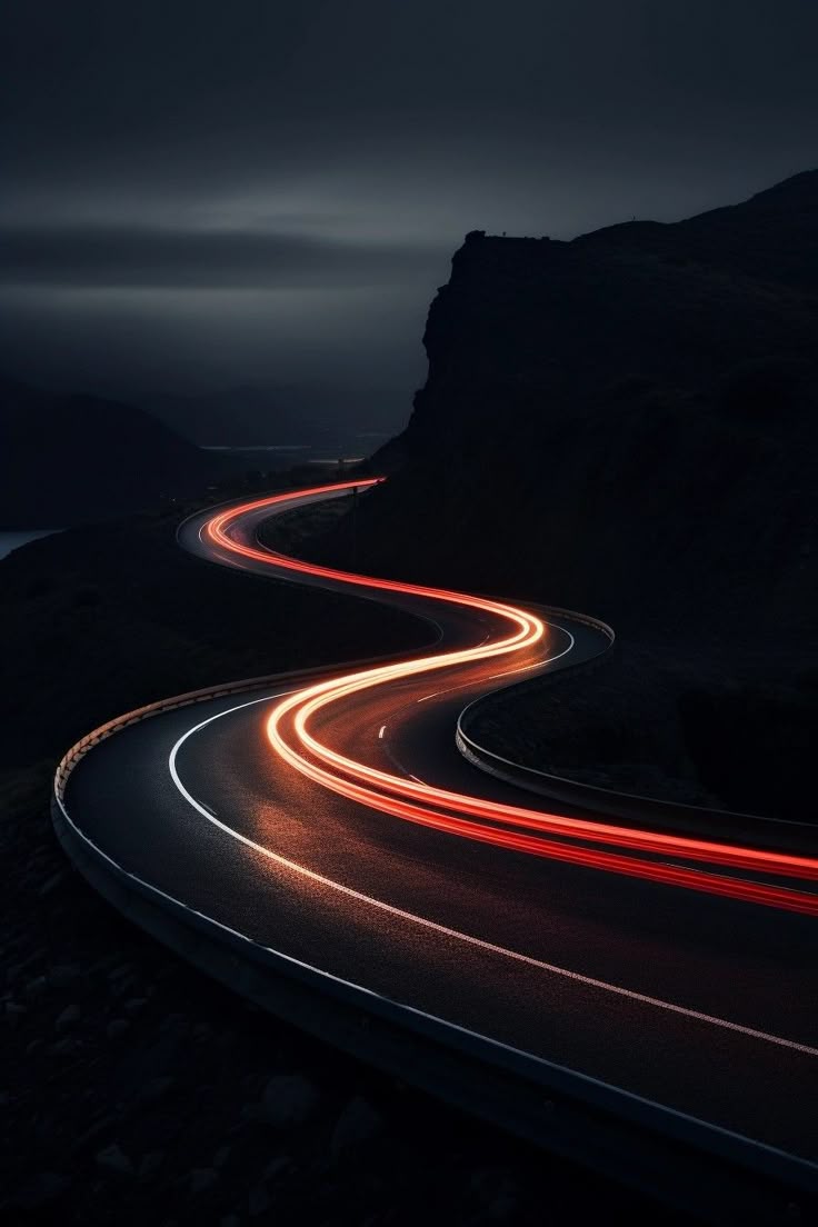 Route de montagne de nuit dessinée par les feux des véhicules