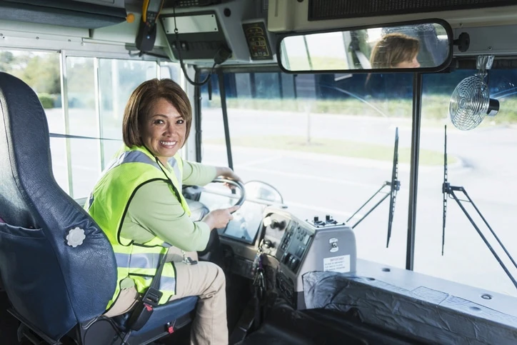 Conductrice installée au poste de conduite d’un autocar